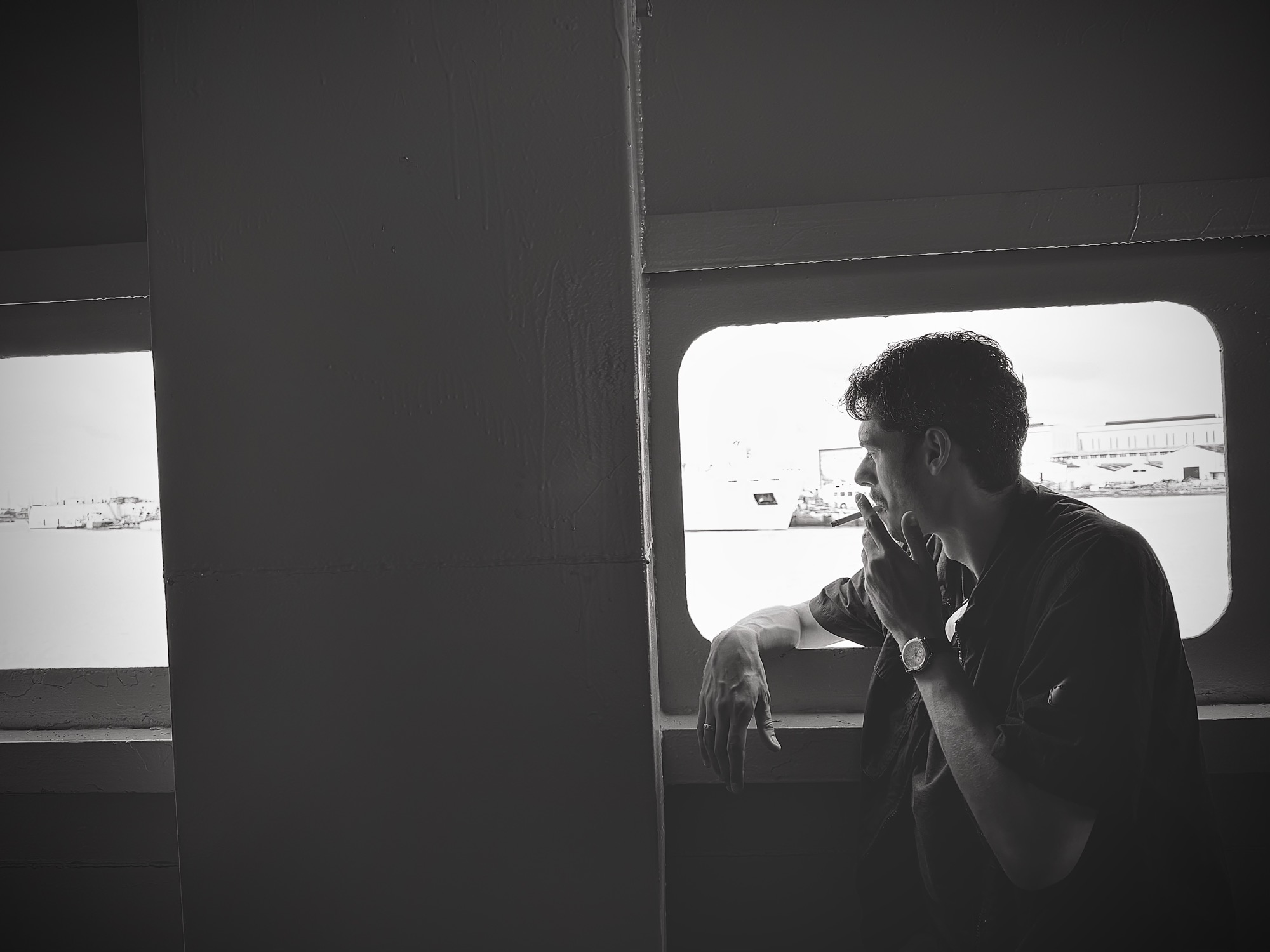 Rory looking out of a ferry window, cigarette in hand